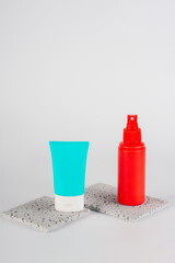 Plastic white tube for cream or lotion. Skin care or sunscreen cosmetic, Cosmetic red bottle....