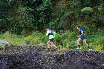 Asian Indonesian couple trail running outdoors, active sustainable lifestyle exercise