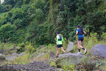 Asian Indonesian couple trail running outdoors, active sustainable lifestyle exercise