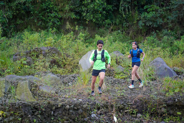 Asian Indonesian couple trail running outdoors, active sustainable lifestyle exercise