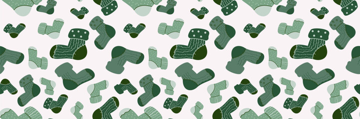 Seamless vector pattern of cozy green socks with various patterns on a soft pink background. Ideal for winter fashion, holiday textiles, digital decor, and warm, comfortable designs.