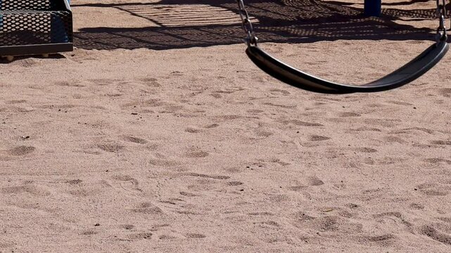 Swinging flat swing Seat Over Sandy Ground on a sunny day at Falcon Field Park in Mesa, Arizona