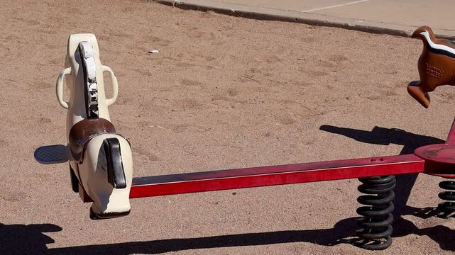 classic spring-mounted horse ride on sandy ground on a sunny day at Falcon Field Park in Mesa