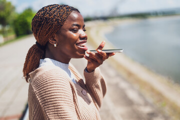 Young black woman is talking on the phone. She is happy and smiling.
