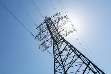A tall power tower with wires and a clear blue sky