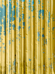 The image is of a yellow and blue metal surface with a lot of paint chipping off