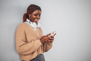 Portrait of young black woman who is messaging on smartphone.