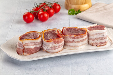 Raw pork tenferloin with bacon