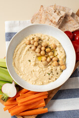 Fresh hummus in a bowl with pita, celery and carrots. Chickpea dishes. 