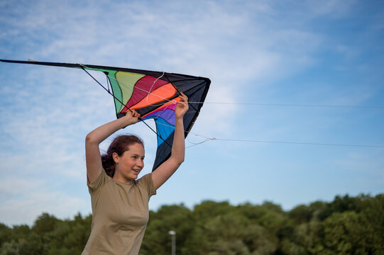 15 years old girl playing with a kite. Flying the kite, summer time