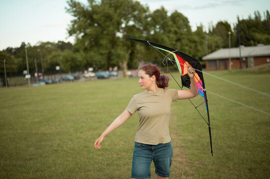 Teen age girl playing with a kite. Flying the kite, summer time