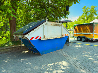 A vibrant and colorful waste container is prominently placed amidst lush greenery in an outdoor...