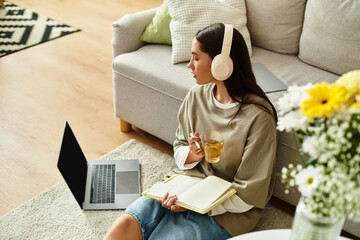 Young woman enjoying a cozy afternoon at home while sipping tea and journaling