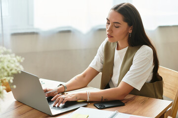 Young woman enjoys productive time at home while working on her laptop in a cozy space