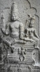 Beautifully carved sculpture of deities and traditional patterns on the outer wall of a historic Indian temple