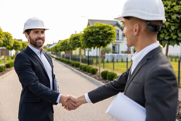 Construction team celebrating project with handshake