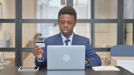 African Businessman Enjoying Online Banking in Office
