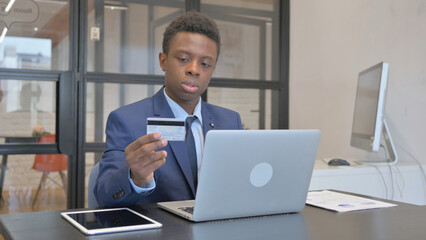 Young African Businessman Enjoying Online Banking at Workplace