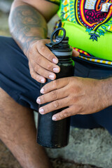 Close-up of a tourist holding a reusable water bottle, resting during a tranquil vacation in Costa Rica