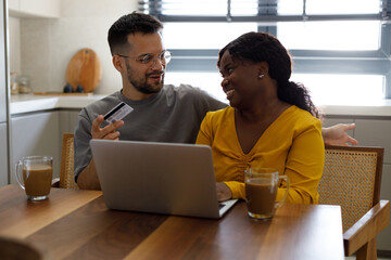 Shot of a young couple sitting together in the living room and using a digital tablet for online...