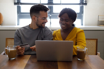 Shot of a young couple sitting together in the living room and using a digital tablet for online shopping