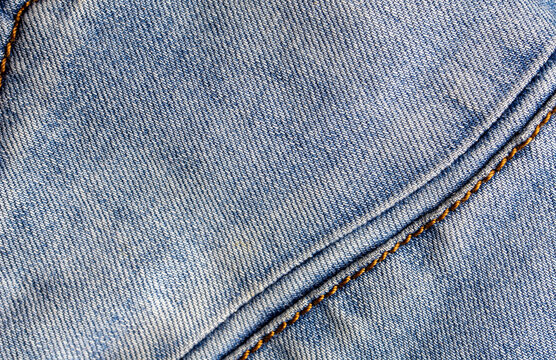Closeup old blue denim with seam background