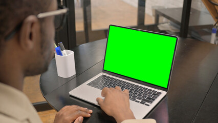 African Man Working on Laptop with Green Screen