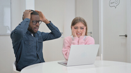 Business People Shocked with Online Loss on Laptop