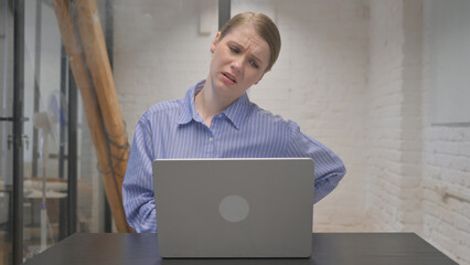 Young Woman with Back Pain Working on Laptop