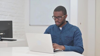 Middle Aged African Man Typing on Laptop