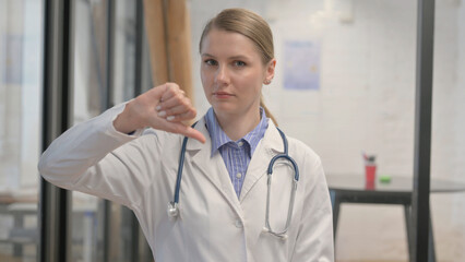 Portrait of Young Female Doctor with Thumbs Down