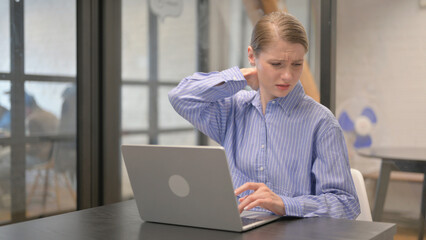 Young Woman with Neck Pain Working on Laptop