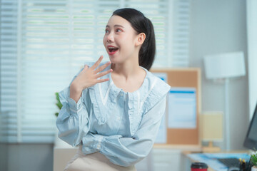 Confident beauty Asian office woman in a formal blouse hard working at her desk, reviewing a...
