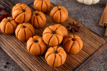 Halloween spicy mini cheesecakes with pumpkin puree in the form of small pumpkins. Halloween or Thanksgiving dessert.