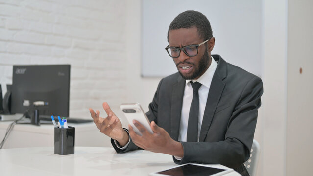 Businessman Reacting with Disbelief to His Phone