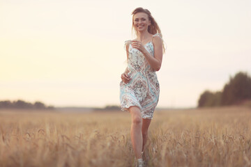 girl runs through an agricultural field summer