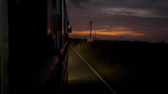 Traveling Bus Captures Orange Night Sky From Front Window View.