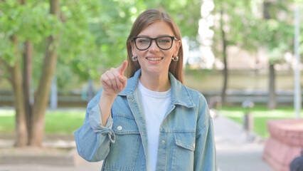 Young Woman Pointing Directly at Viewer Outdoors