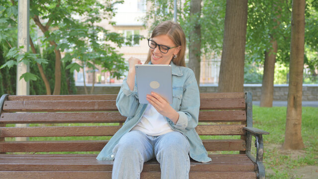 Casual Woman Reacting with Surprise to Content on a Tablet