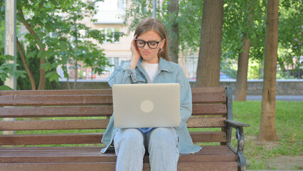 Woman with Headache Using Laptop in Park