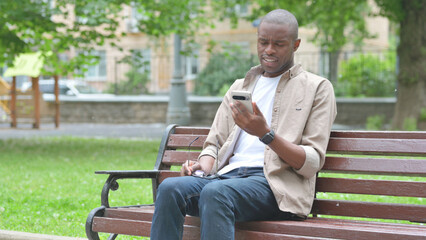 Young African Man with a Smartphone and an Expressive Gesture