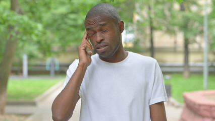 Troubled Young African Man with Headache Outdoors
