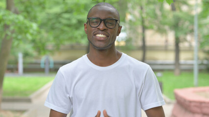 Interacting Young African Man Talking for Video Chat Outdoors