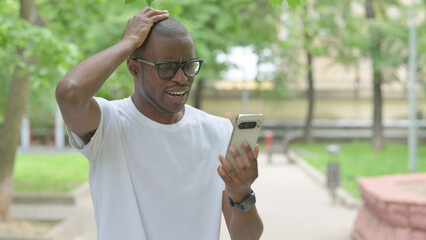 Upset Young African Man Reacting to Phone Content Outdoors
