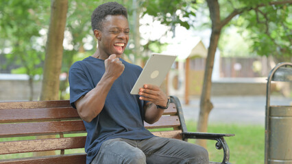 African American Man Celebrating with Surprise to Content on a Tablet