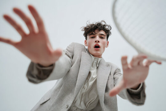 dynamic portrait of young man engaged in finger tennis displaying surprised emotion - Powered by Adobe