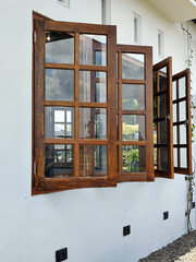 The view of the outer corner of the clean white-walled building shows dark brown wooden windows...