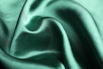 Crumpled green silk fabric as background, closeup