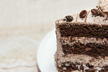 Portion of tasty sweet coffee cake covered with glaze and coffee beans lies in a dessert plate