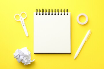 Flat lay composition with open blank notebook on yellow background